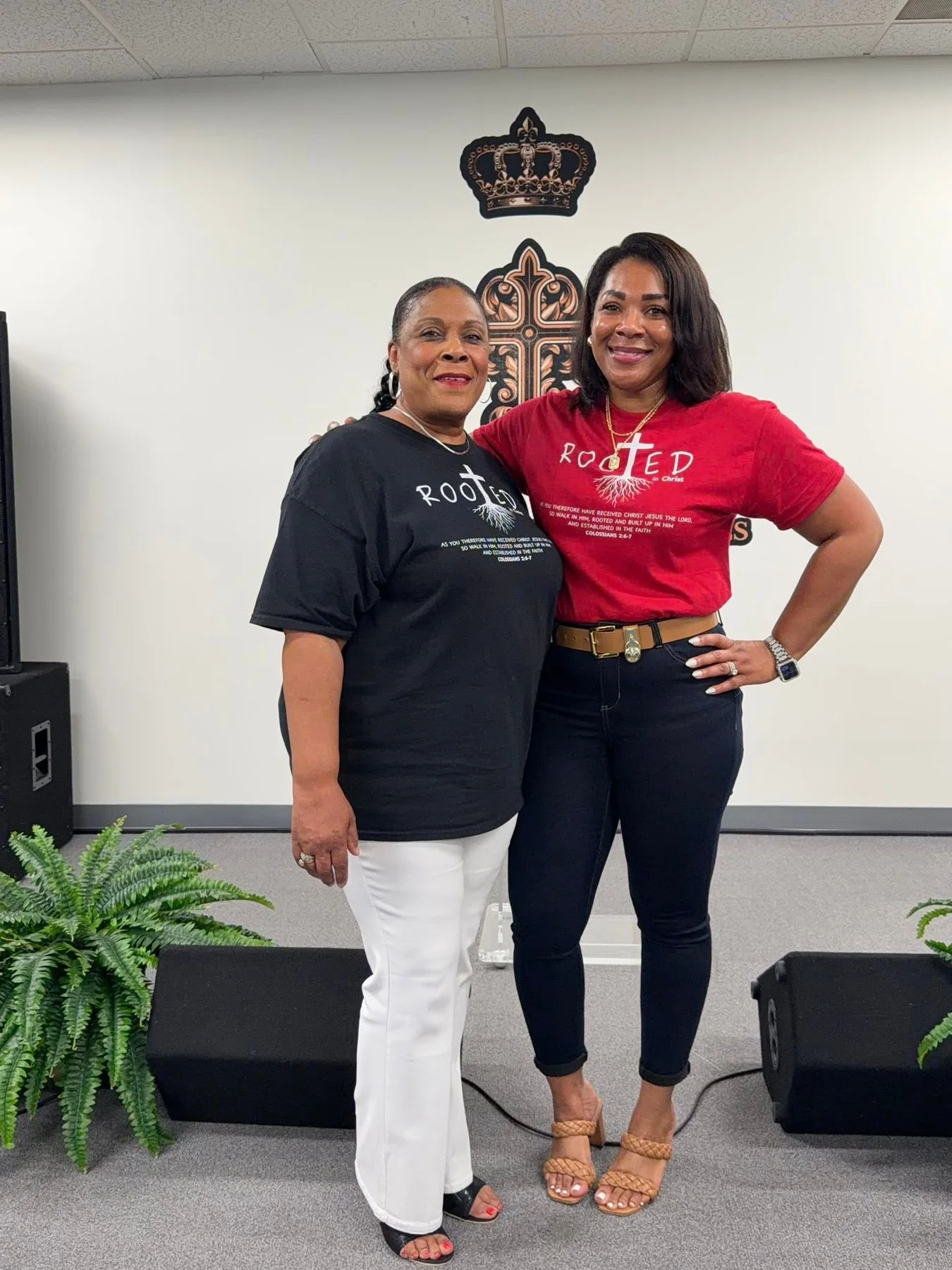 Two women wearing black and red Rooted shirts